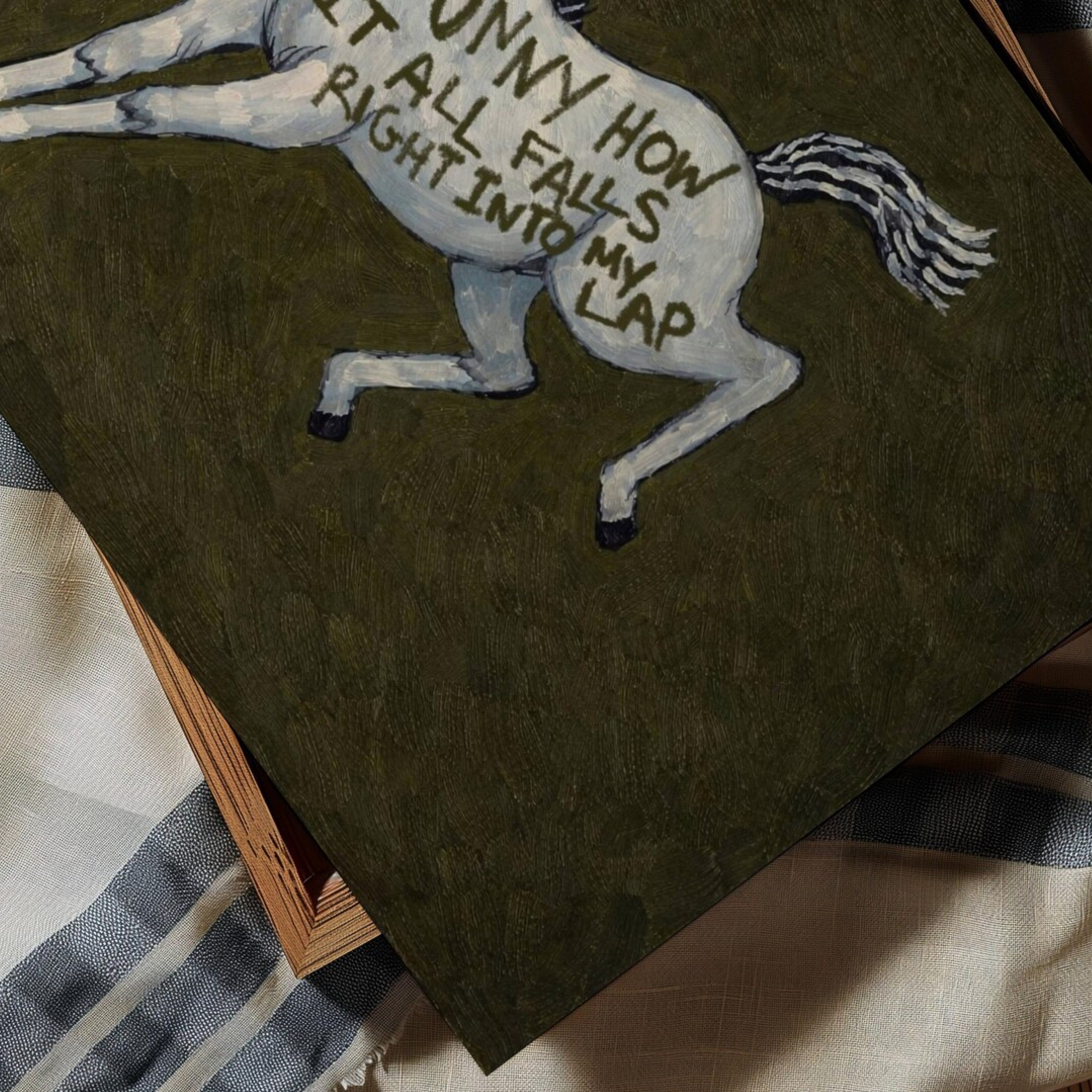 A surreal Symbolic artwork featuring a White Horse running against a deep khaki green background. The Horse has handwritten quote "Funny How It All Falls Right Into my Lap". This is a hand drawn Contemporary Folk art Print Oil Painting.