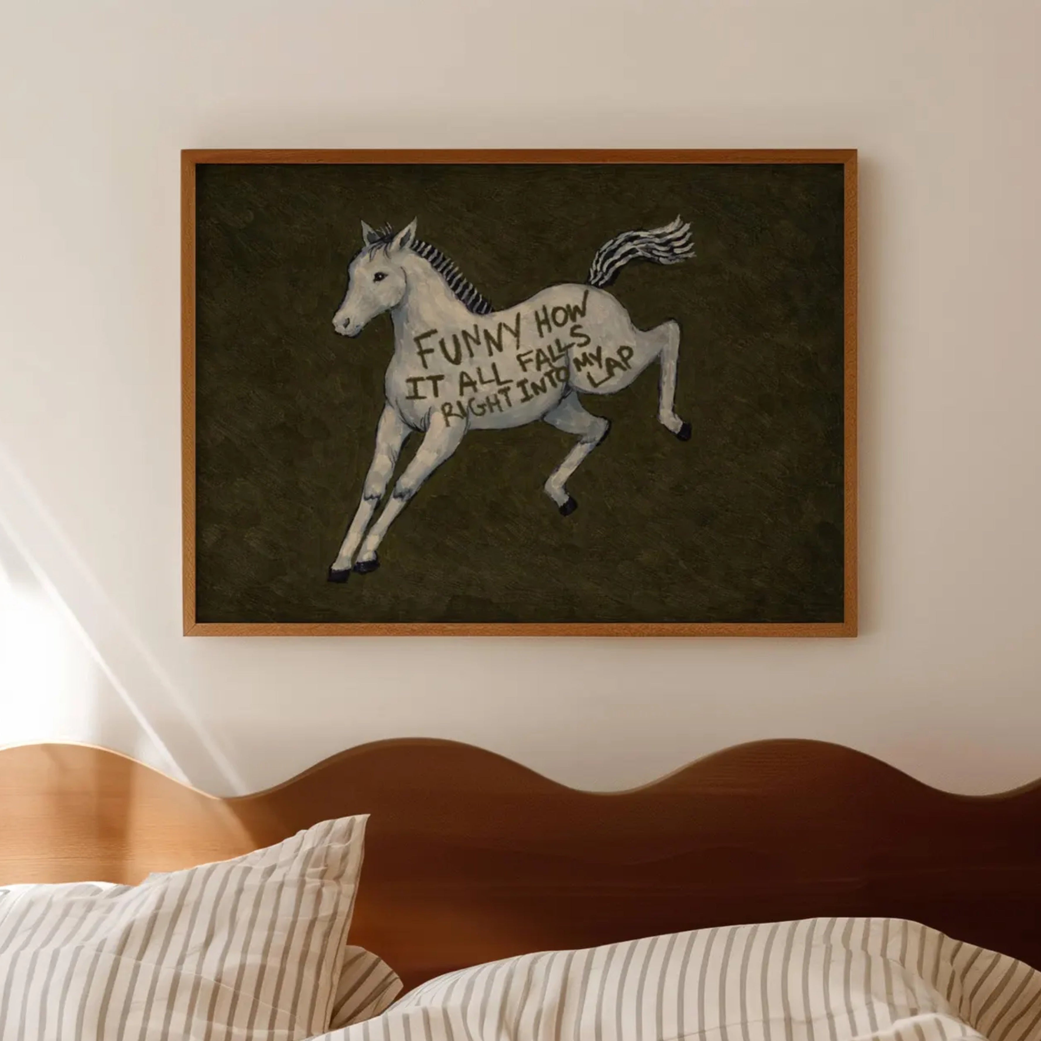 A surreal Symbolic artwork featuring a White Horse running against a deep khaki green background. The Horse has handwritten quote "Funny How It All Falls Right Into my Lap". This is a hand drawn Contemporary Folk art Print Oil Painting.