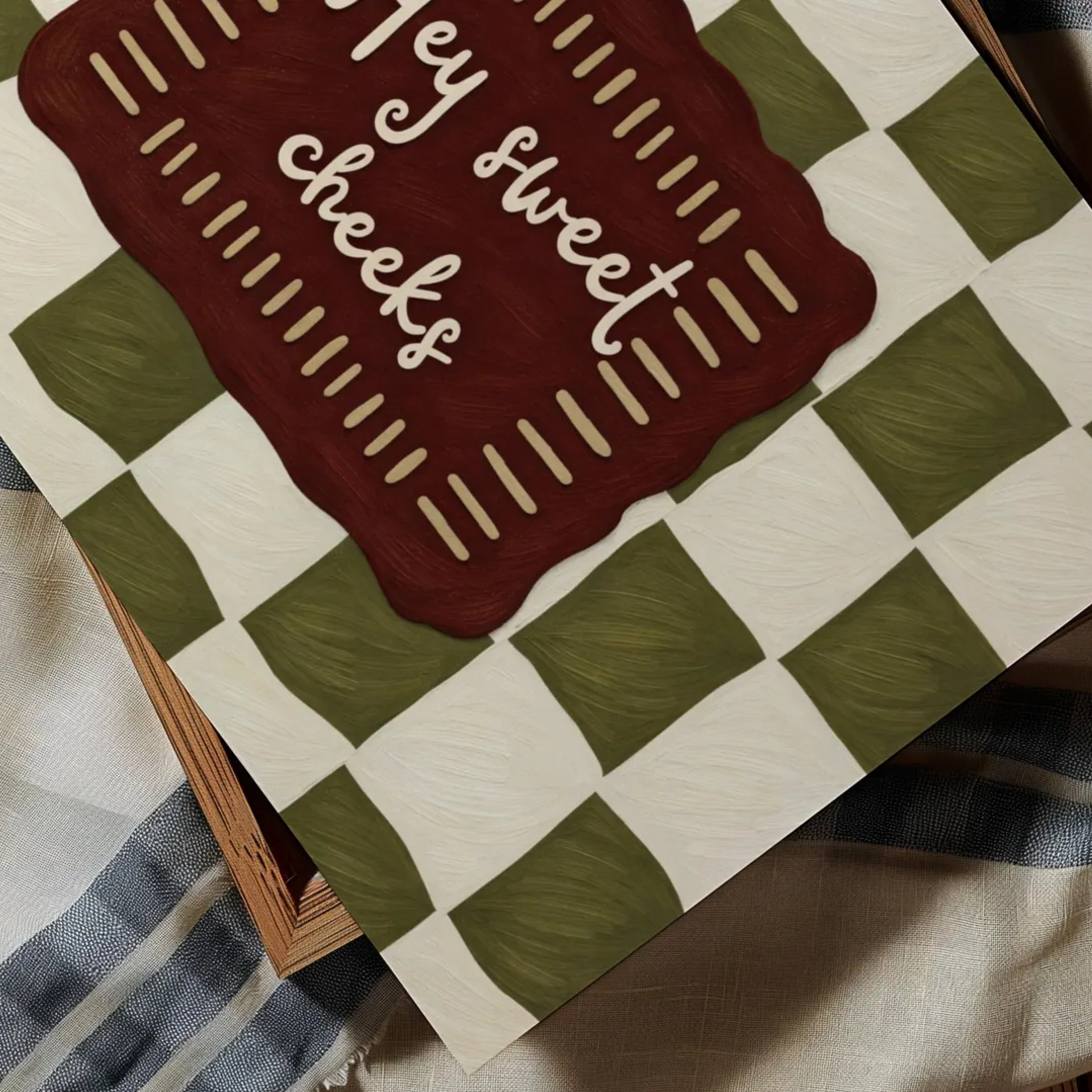 HEY SWEET CHEEKS is a whimsical Retro typography art print designed to bring humour, colour and personality into your bathroom and laundry room. Featuring vintage-inspired Checkered patterns and hand-lettered typography, this artwork captures the nostalgic charm while adding a playful decorative touch to modern interiors. this is a hand drawn Retro quote wall art, ideal for bathrooms, laundry room decor, and cheeky playful interiors. khaki ruby