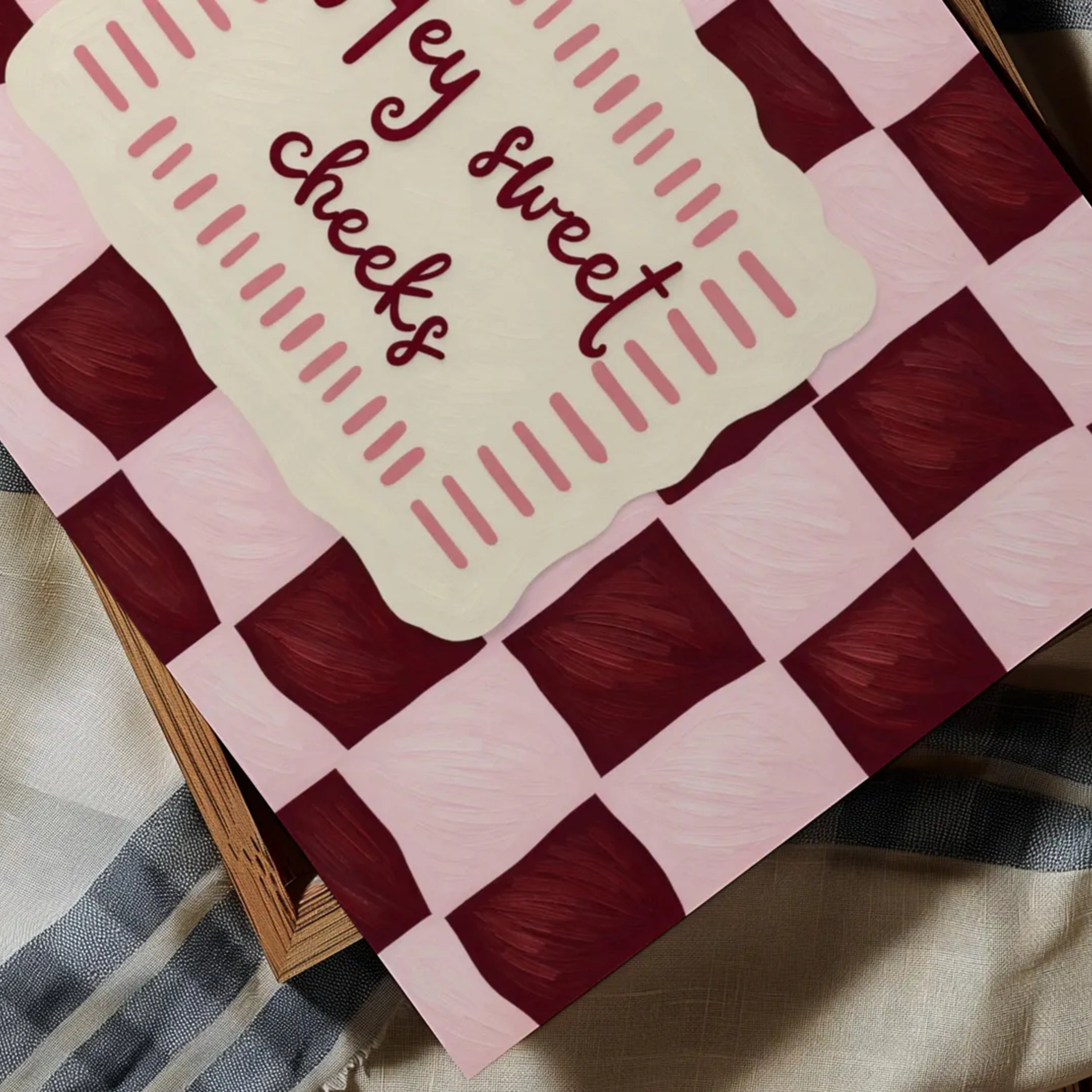 HEY SWEET CHEEKS is a whimsical Retro typography art print designed to bring humour, colour and personality into your bathroom and laundry room. Featuring vintage-inspired Checkered patterns and hand-lettered typography, this artwork captures the nostalgic charm while adding a playful decorative touch to modern interiors. this is a hand drawn Retro quote wall art, ideal for bathrooms, laundry room decor, and cheeky playful interiors. pink burgundy