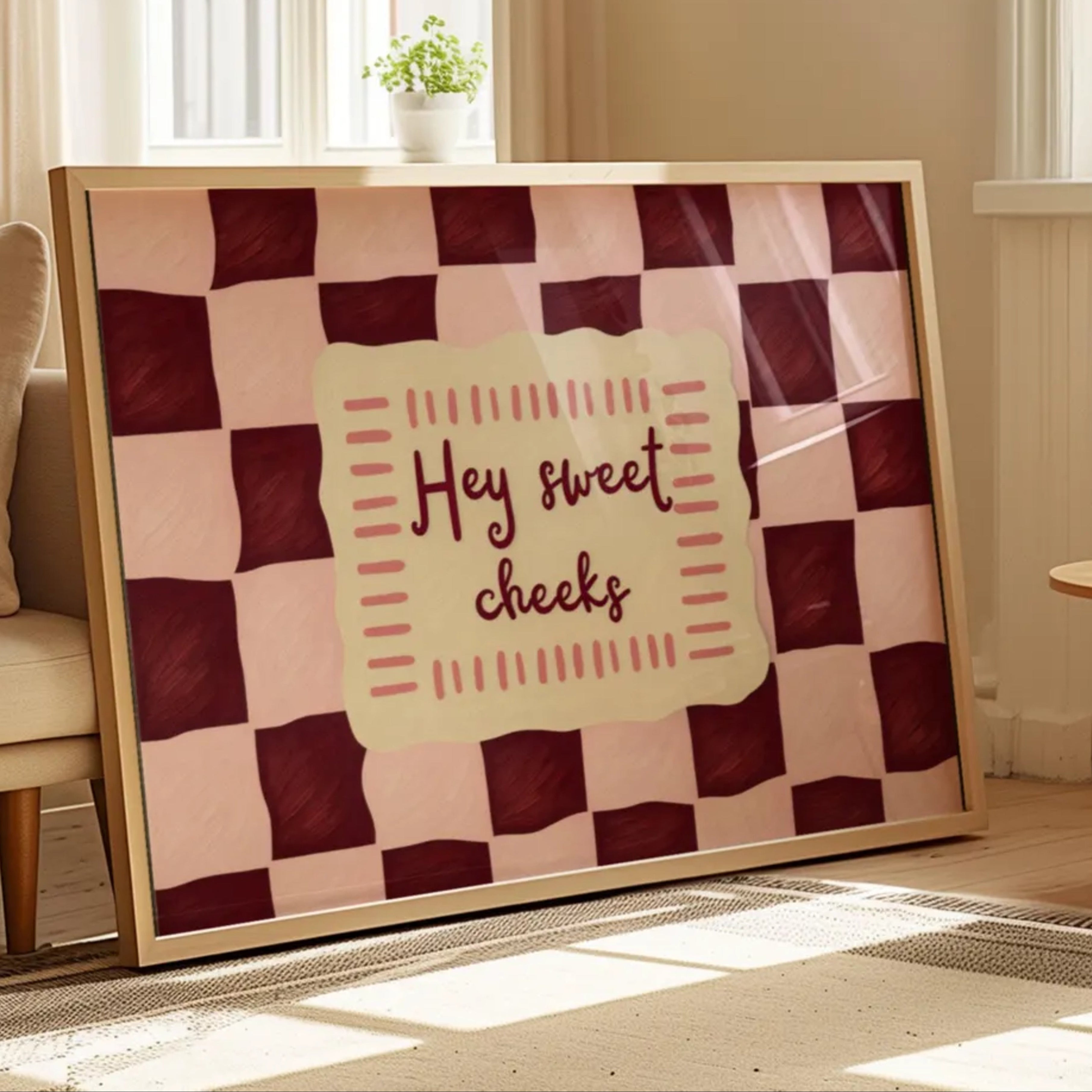 HEY SWEET CHEEKS is a whimsical Retro typography art print designed to bring humour, colour and personality into your bathroom and laundry room. Featuring vintage-inspired Checkered patterns and hand-lettered typography, this artwork captures the nostalgic charm while adding a playful decorative touch to modern interiors. this is a hand drawn Retro quote wall art, ideal for bathrooms, laundry room decor, and cheeky playful interiors. pink and ruby