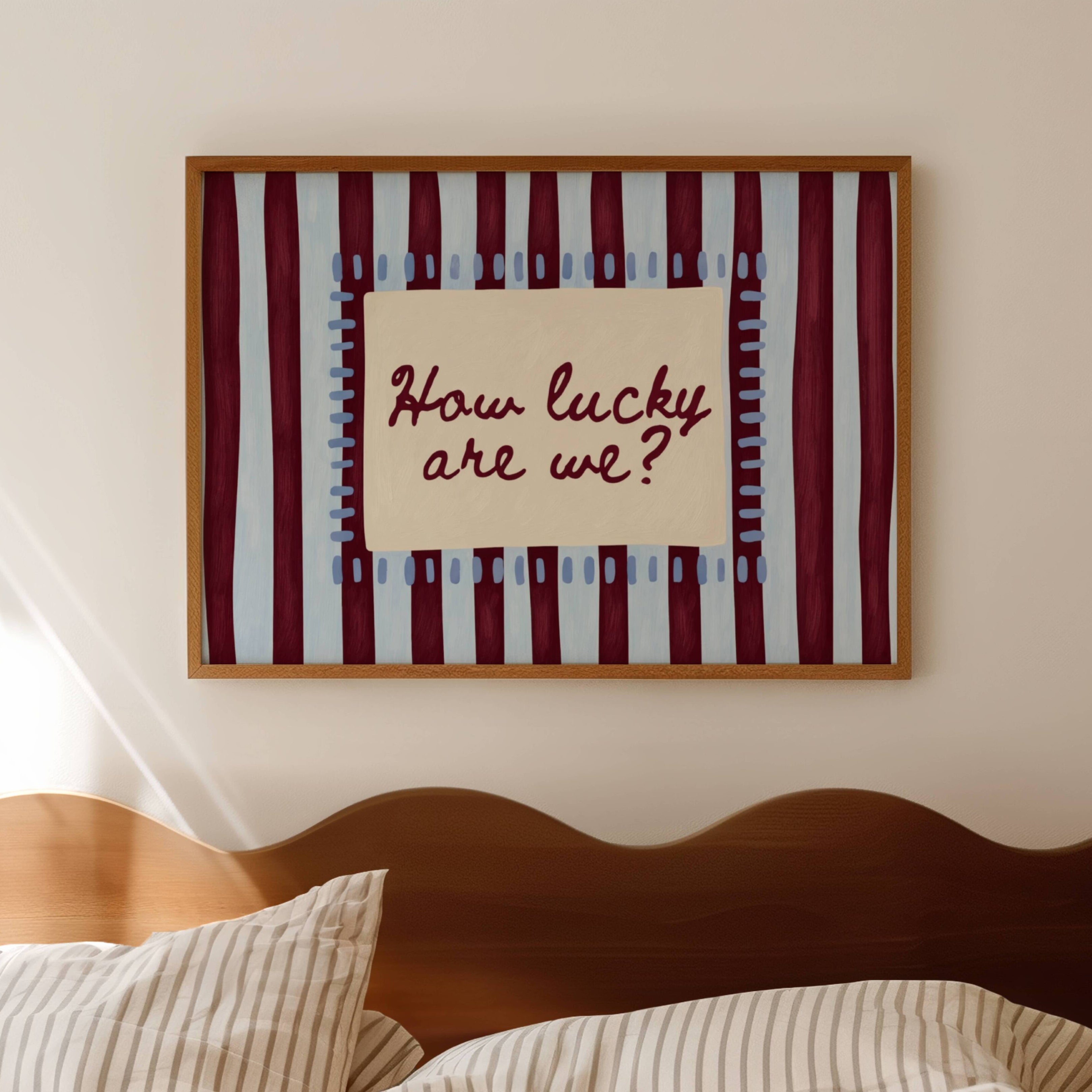 hand drawn Playful typography print with the phrase "How Lucky Are We?" on a blue and ruby burgundy striped background. This is a hand drawn trendy typography wall art print ideal for bedrooms, dorm room decor, gallery walls and playful interiors.