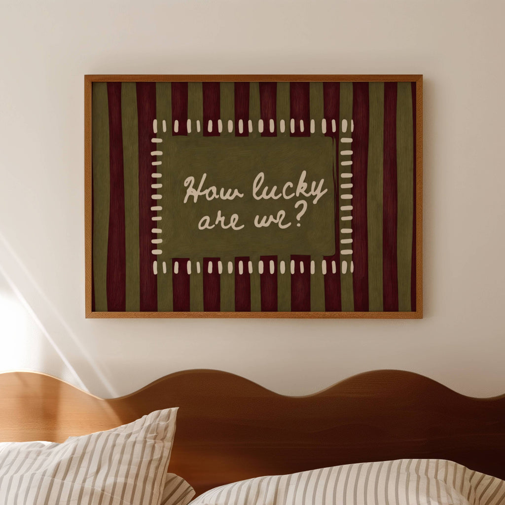 hand drawn Playful typography print with the phrase "How Lucky Are We?" on a khaki and ruby burgundy striped background. This is a hand drawn trendy typography wall art print ideal for bedrooms, dorm room decor, gallery walls and playful interiors.