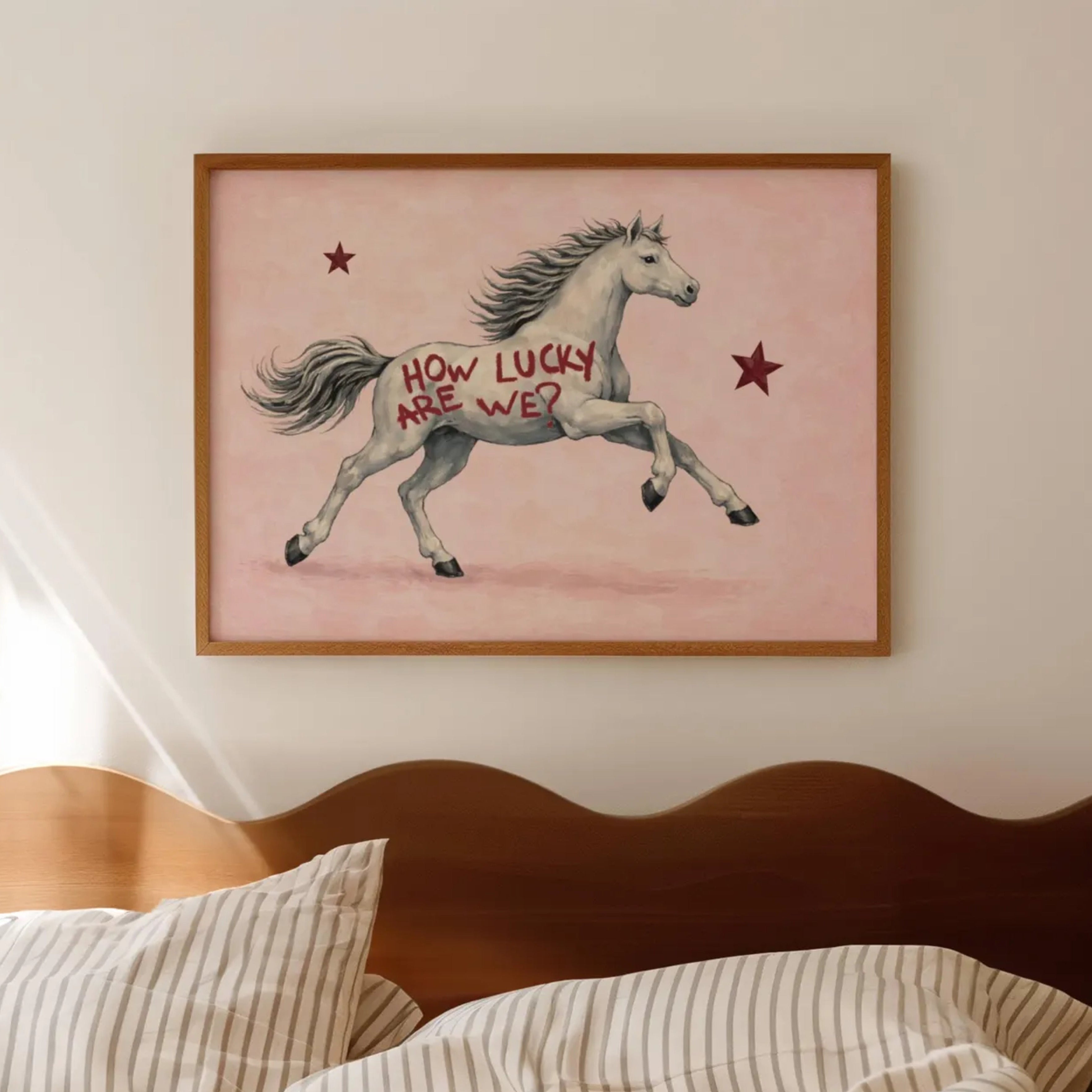 Symbolic Eclectic White Horse with red stars and handwritten quote "How Lucky Are We?" on a soft pink background. This is a hand drawn Contemporary Folk art Print Oil Painting.
