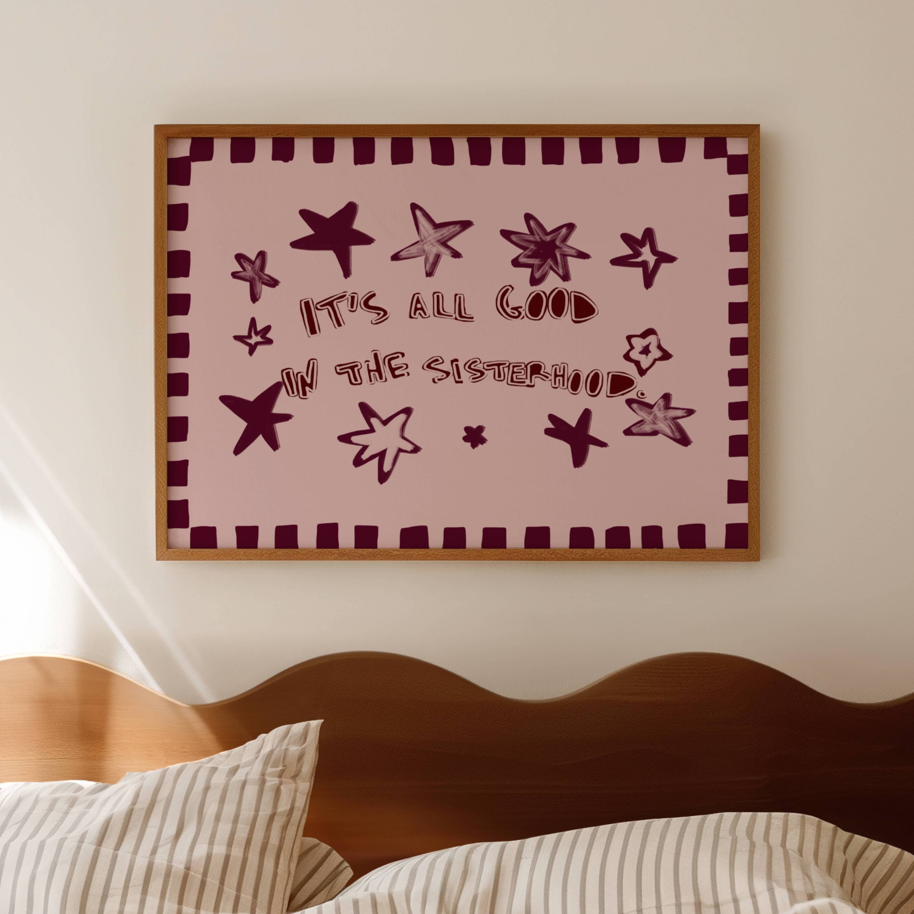 Playful typography print with the phrase "It's all good in the sisterhood" on a pink background with burgundy stars. This is a hand drawn trendy typography wall art print ideal for girly bedrooms, dorm room decor, sorority houses and gift for your best friend.