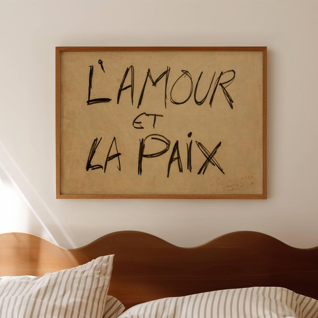 Framed artwork with 'L'Amour et La Paix' text above a bed.