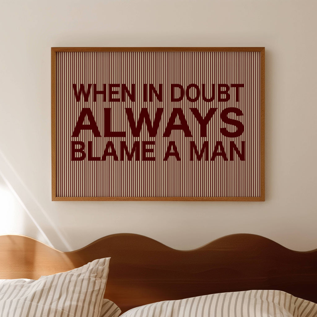 hand drawn Playful Funny typography print with the phrase "WHEN IN DOUBT ALWAYS BLAME A MAN" in a retro striped burgundy ruby canva. This is a trendy funny typography wall art print ideal for above bed, bedrooms, dorm room decor, living rooms and kitchens, gallery walls and playful interiors. The perfect Cool Girl Apartment decor