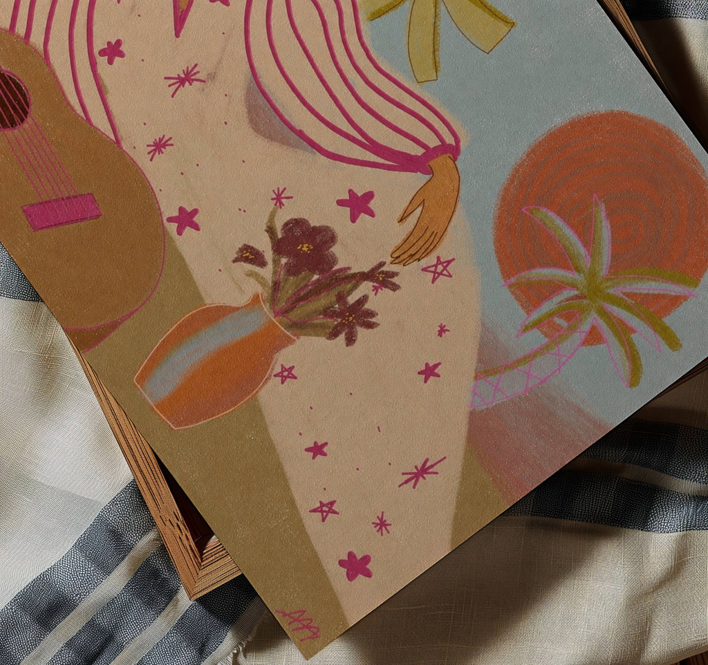 A close-up of a printed artwork featuring a colorful bohemian-style illustration, resting on a striped fabric surface.
